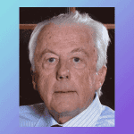 Unfocused elderly man with white hair and blue shirt, portrait, serious expression.