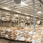 Large warehouse with stacks of printed direct mail pieces ready for distribution.