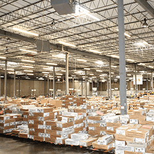 Large warehouse with stacks of printed direct mail pieces ready for distribution.