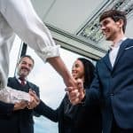 Handshake between business professionals in an office, representing direct marketing and direct mail solutions from SG360°.