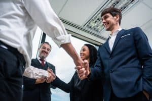 Handshake between business professionals in an office, representing direct marketing and direct mail solutions from SG360°.