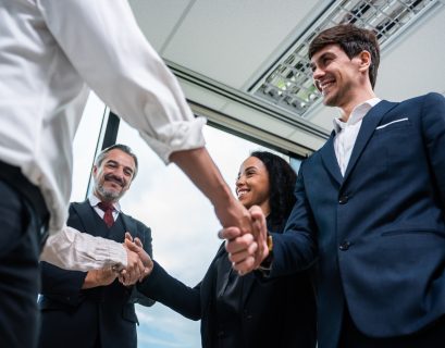Handshake between business professionals in an office, representing direct marketing and direct mail solutions from SG360°.