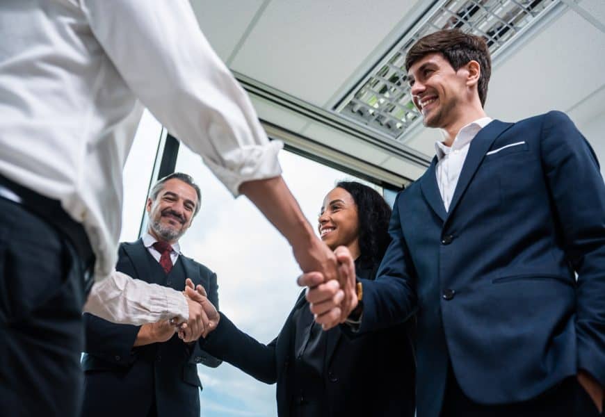 Handshake between business professionals in an office, representing direct marketing and direct mail solutions from SG360°.