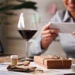- Engaging woman using smartphone with direct mail marketing materials on table.