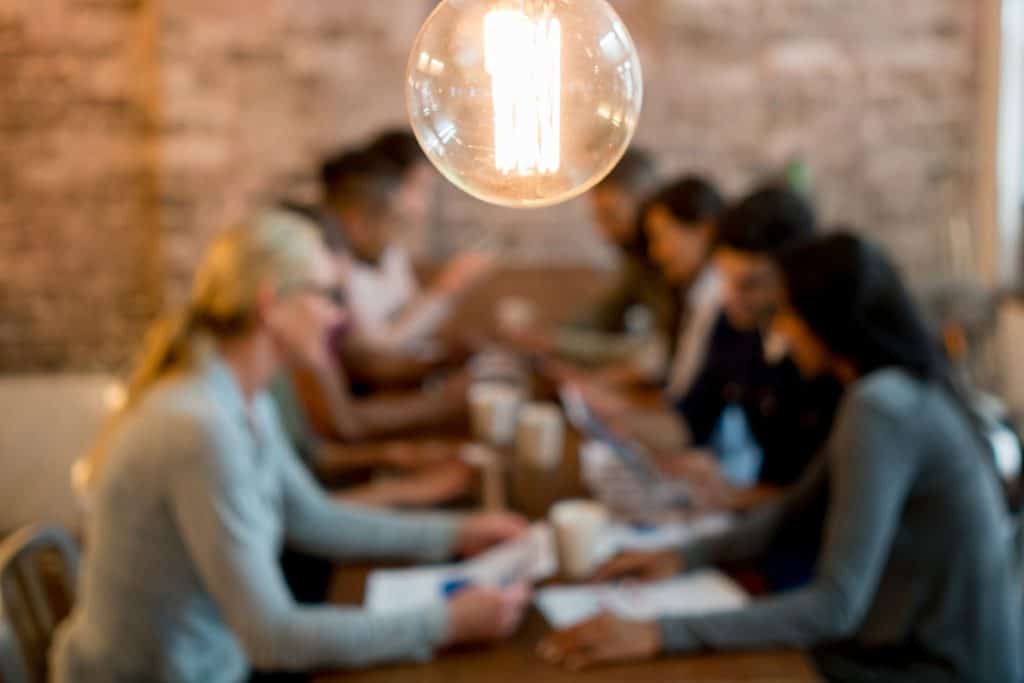 People collaborating around a table in a modern office setting, discussing marketing strategies.